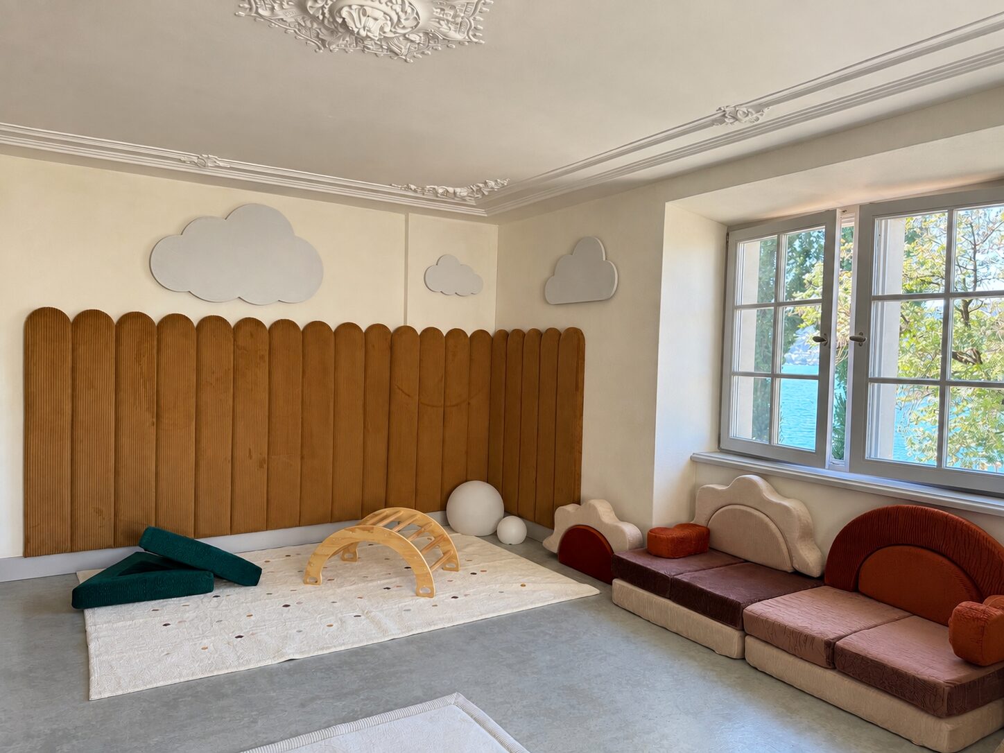 Lounge with a wooden fluted wall, soft play seating and a window onto the lake
