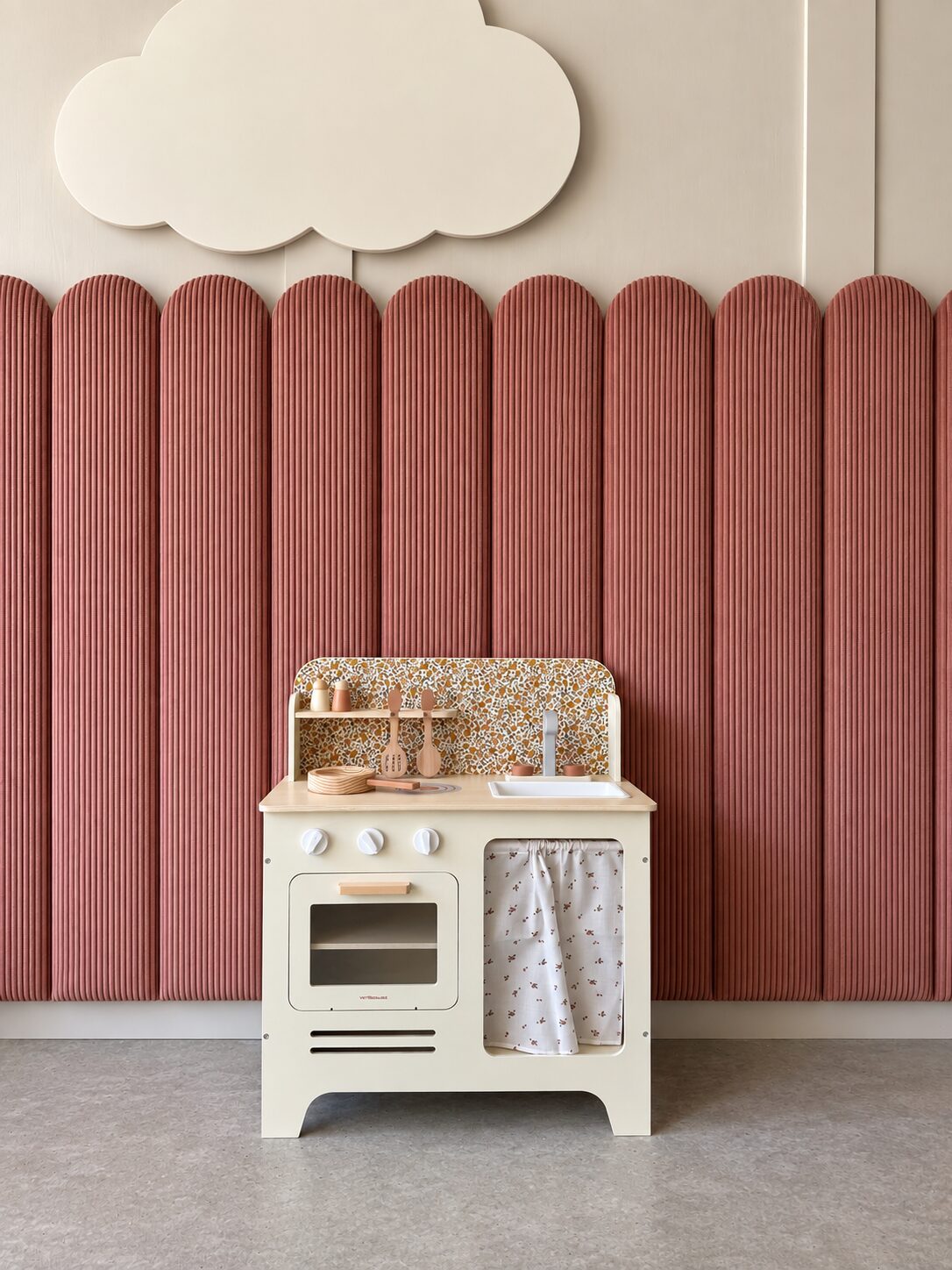 Play kitchen against a rose fluted wall beneath a soft cloud