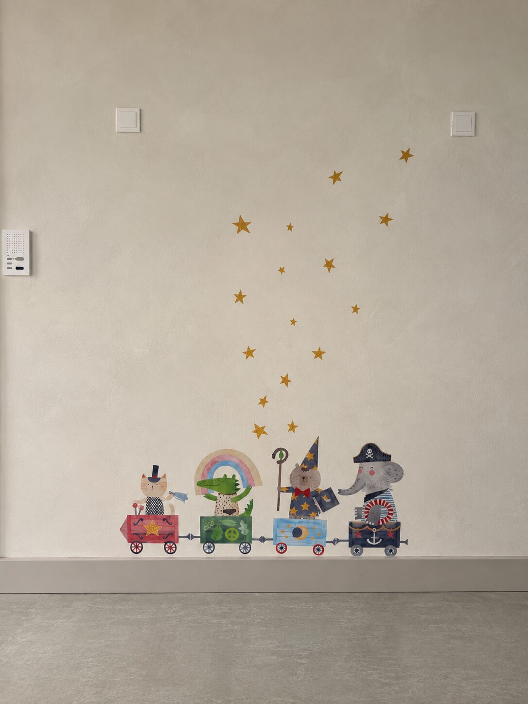 Wall decorated with golden stars and a little train of animal characters